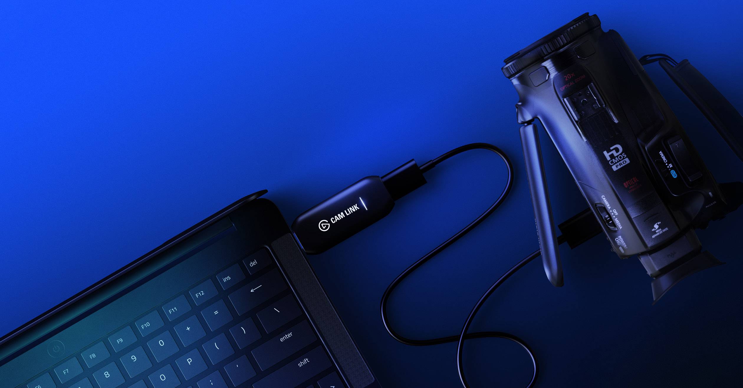 L'appareil 'Cam Link' connecte une caméra vidéo à un ordinateur portable via un câble USB. Il permet la transmission des prises de vue de la caméra sur l'ordinateur portable.