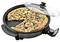 Une poêle électrique avec un couvercle en verre, dans laquelle se trouve une pizza garnie de légumes. Une part de pizza a déjà été découpée.