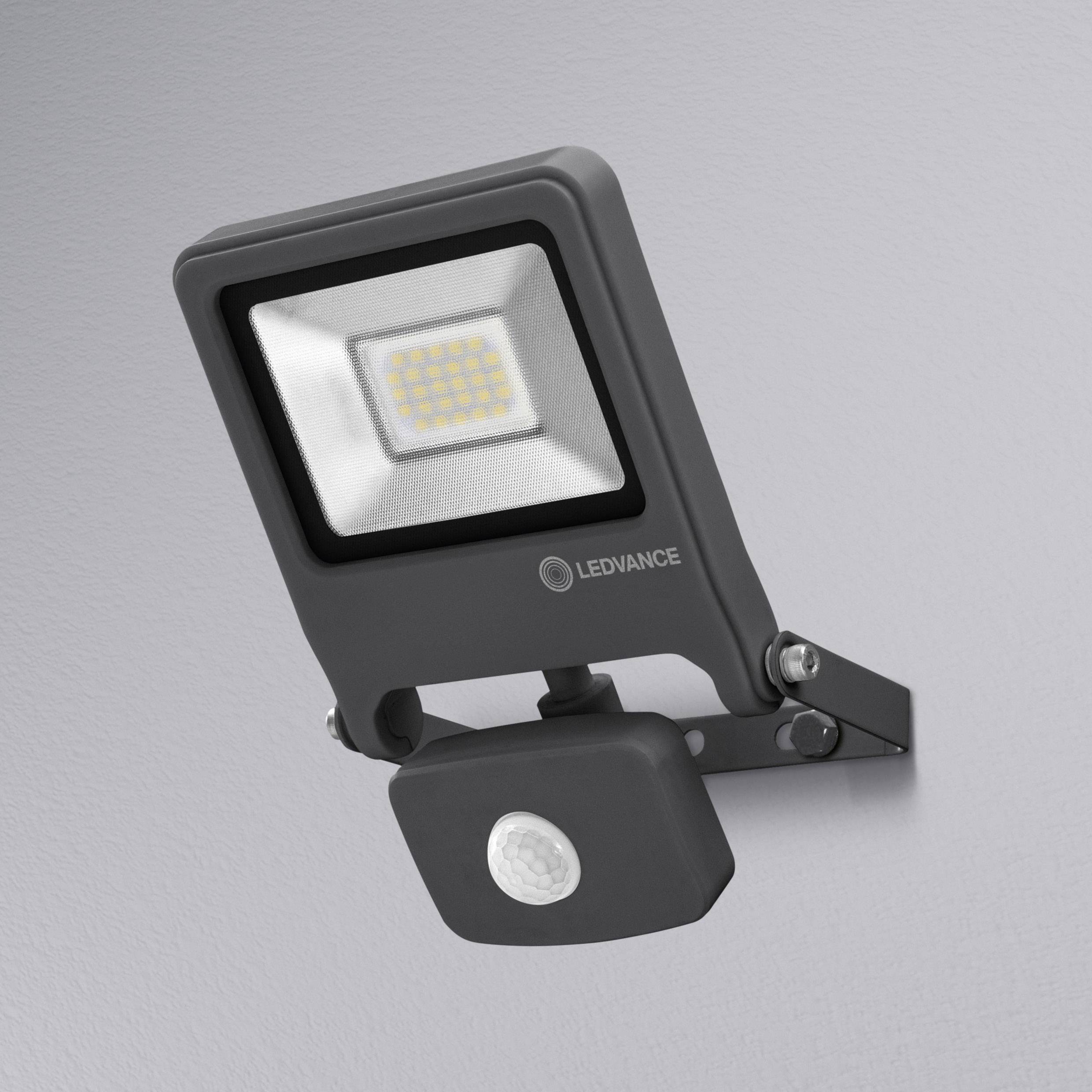 Applique extérieure avec projecteur LED rectangulaire et détecteur de mouvement, installée sur un mur gris.