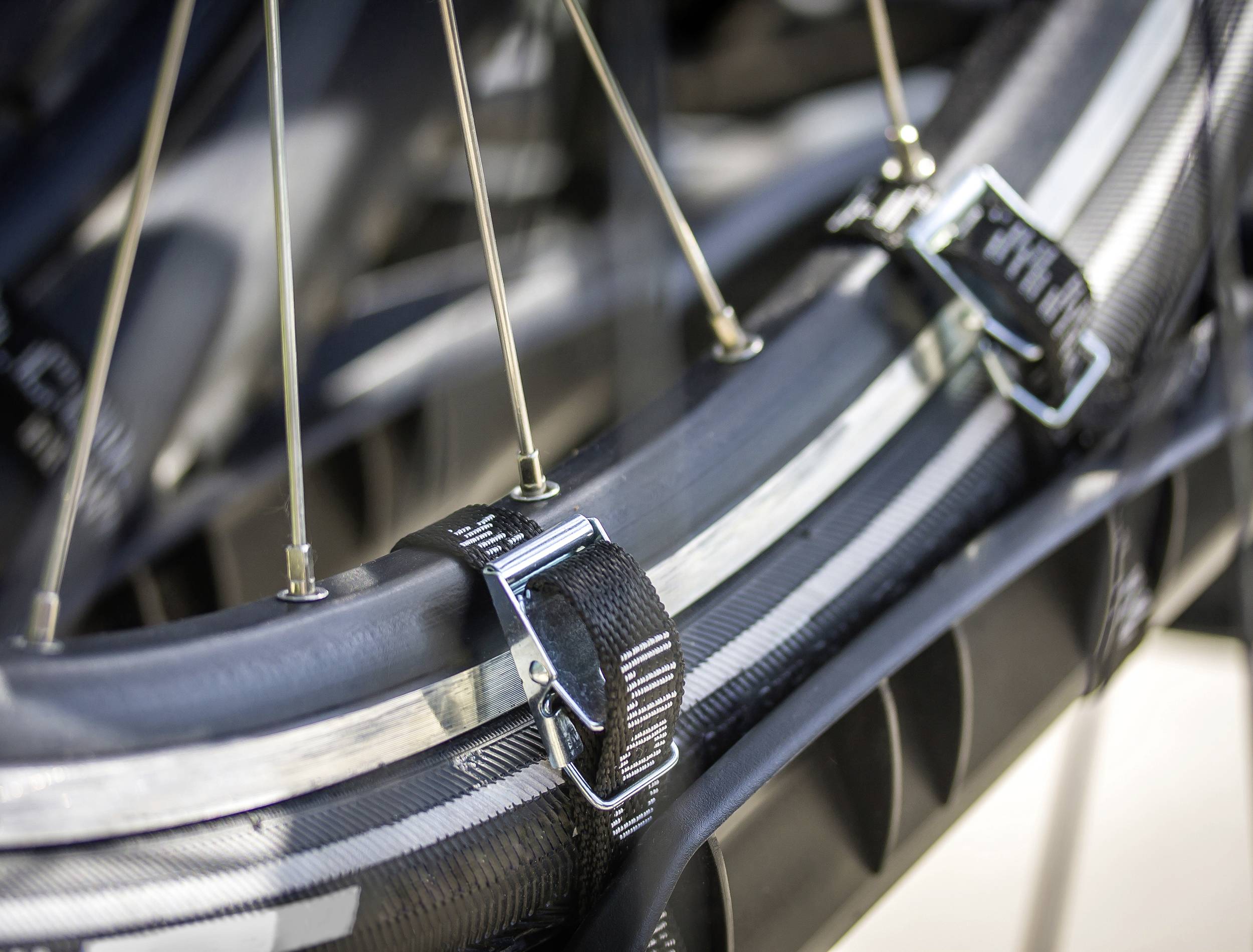 Gros plan sur un pneu de vélo avec une bande de jante et des rayons, montrant les fixations et la structure.