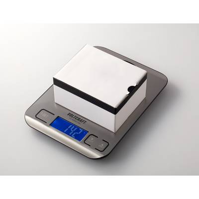 Une balance de cuisine numérique affiche un poids de 1,42 kg. Un paquet carré blanc est posé sur la balance.