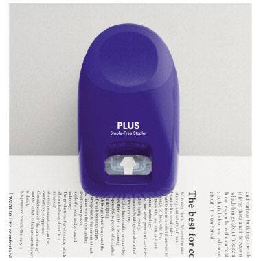 Un classeur bleu sans agrafe est posé sur une feuille de papier. Inscription sur le classeur : « PLUS Staple-Free Stapler ».