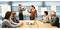 Six personnes sont réunies dans une salle de réunion devant un tableau. Deux personnes sont debout et écrivent, tandis que quatre sont assises à la table. Un projecteur est posé sur la table.