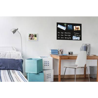 Chambre à coucher avec un bureau. Un tableau d'affichage avec des photos est accroché au mur, à côté d'une photo de deux personnes. Bureau avec des accessoires de bureau.