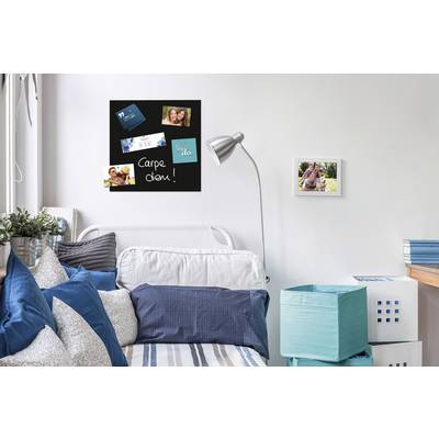 Une chambre moderne avec un lit de jour blanc, décoré de coussins bleus. Sur le mur est accroché un tableau noir avec des photos et l'inscription 'Carpe diem !'.