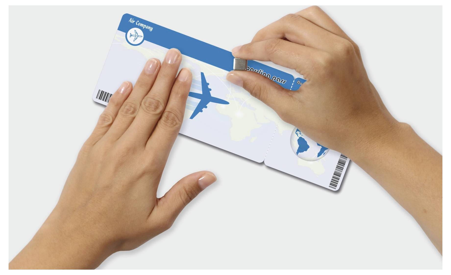 Les mains tenant une carte de crédit tandis qu'une main gratte une bande de sécurité bleue, révélant une carte à thème voyage avec une icône d'avion.