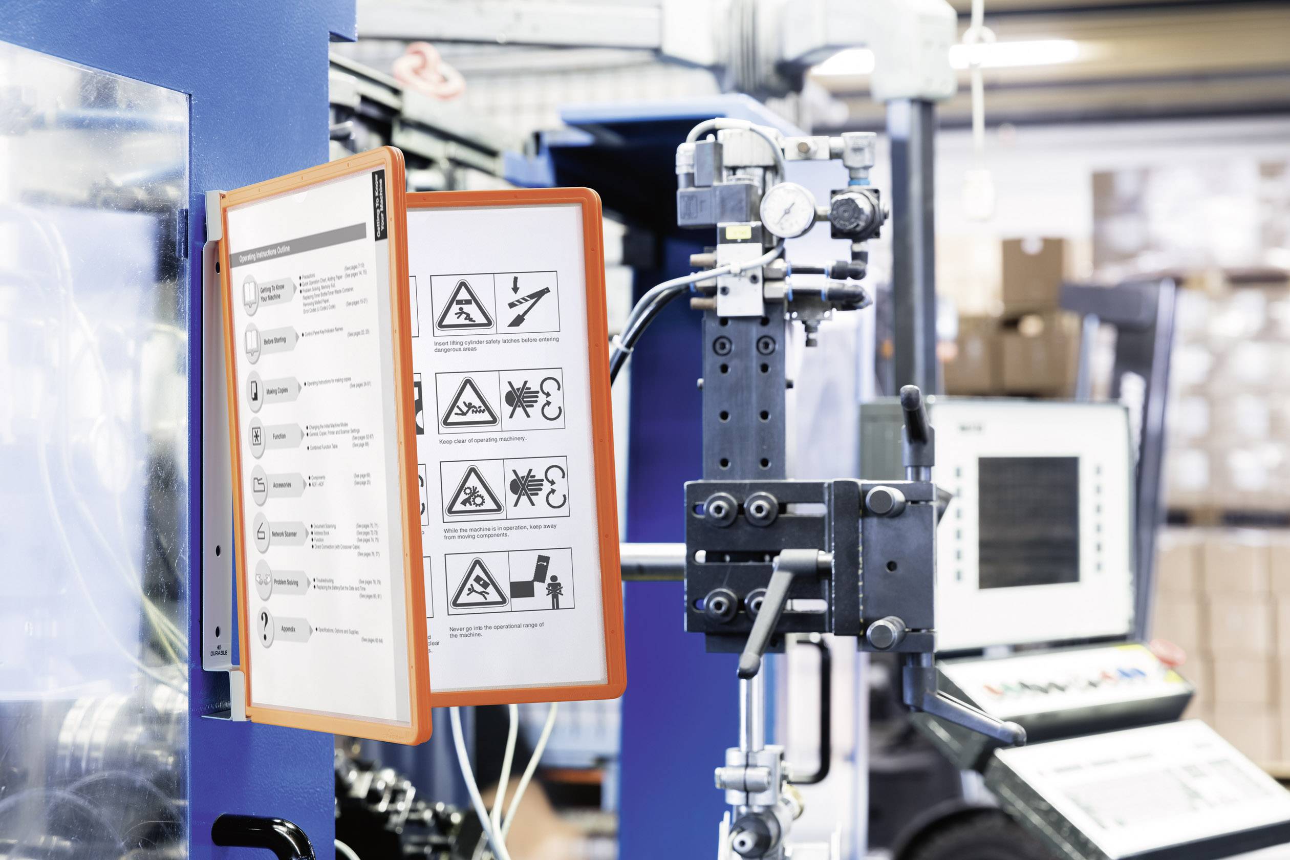 Des panneaux indicateurs sur une machine de production affichent des instructions de sécurité avec des symboles et des textes qui illustrent les mesures de protection.