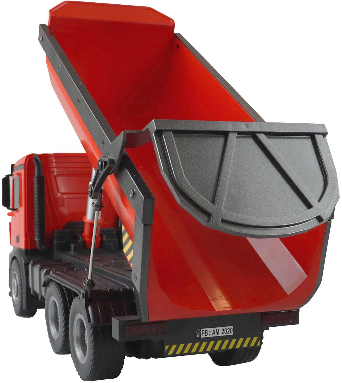 Un camion-benne jouet rouge avec une benne basculante ouverte est visible de côté.