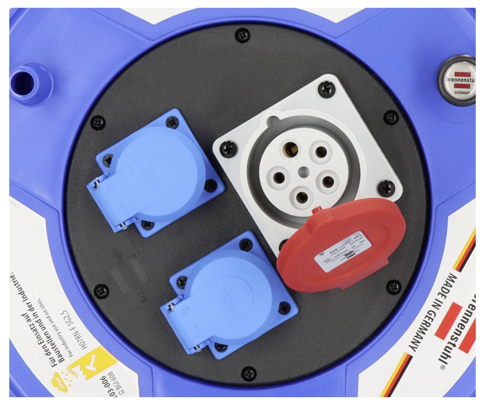 Gros plan d'un panneau de connecteurs électriques industriels bleus avec plusieurs prises, incluant une prise circulaire blanche et des ports bleus/rouges couverts.