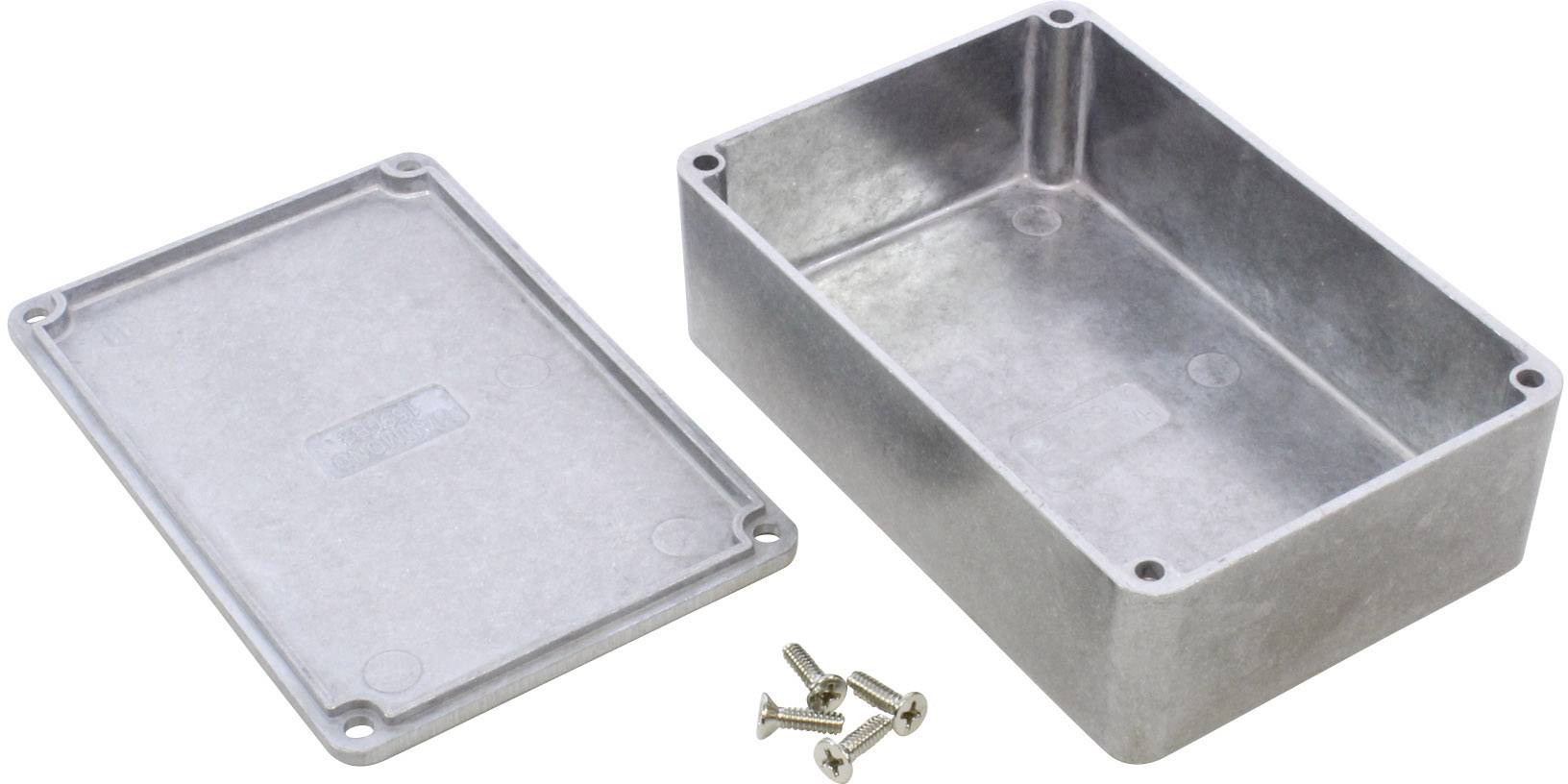 Un boîtier métallique rectangulaire gris avec son couvercle retiré, quatre vis à côté pour les composants électroniques.