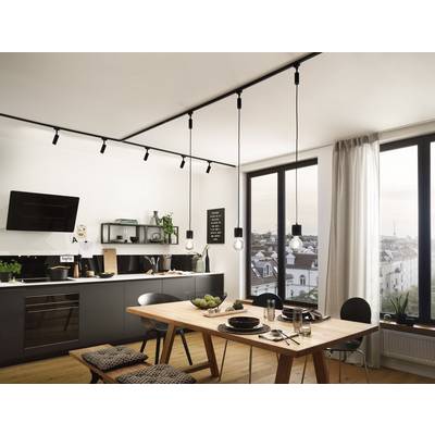 Cuisine moderne avec table à manger, lampes suspendues et grandes fenêtres offrant une vue sur la ville. Atmosphère lumineuse et accueillante.