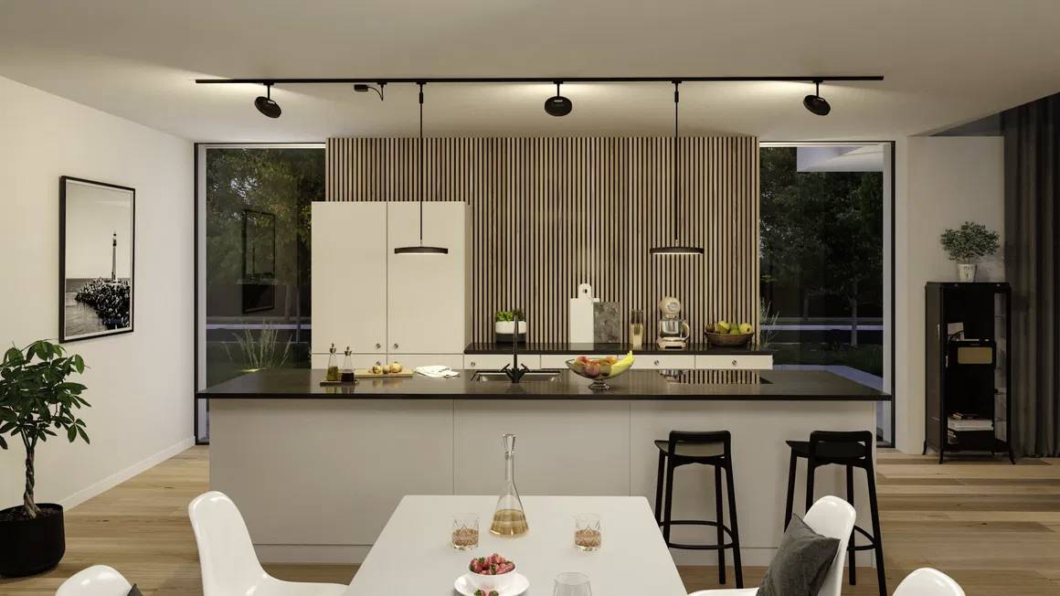 Cuisine moderne avec un grand îlot central, des tabourets de bar et une table dressée au premier plan ; des touches de bois clair et des plantes ornent l'espace.