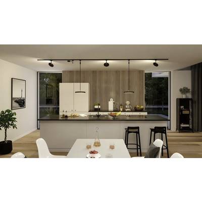 Cuisine moderne avec un grand îlot central, des tabourets de bar et une table dressée au premier plan ; des touches de bois clair et des plantes ornent l'espace.