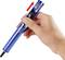 Une main tient une pompe de dessoudage bleue avec un marquage de flèche rouge indiquant le mécanisme de commande sur le dessus de la pompe.