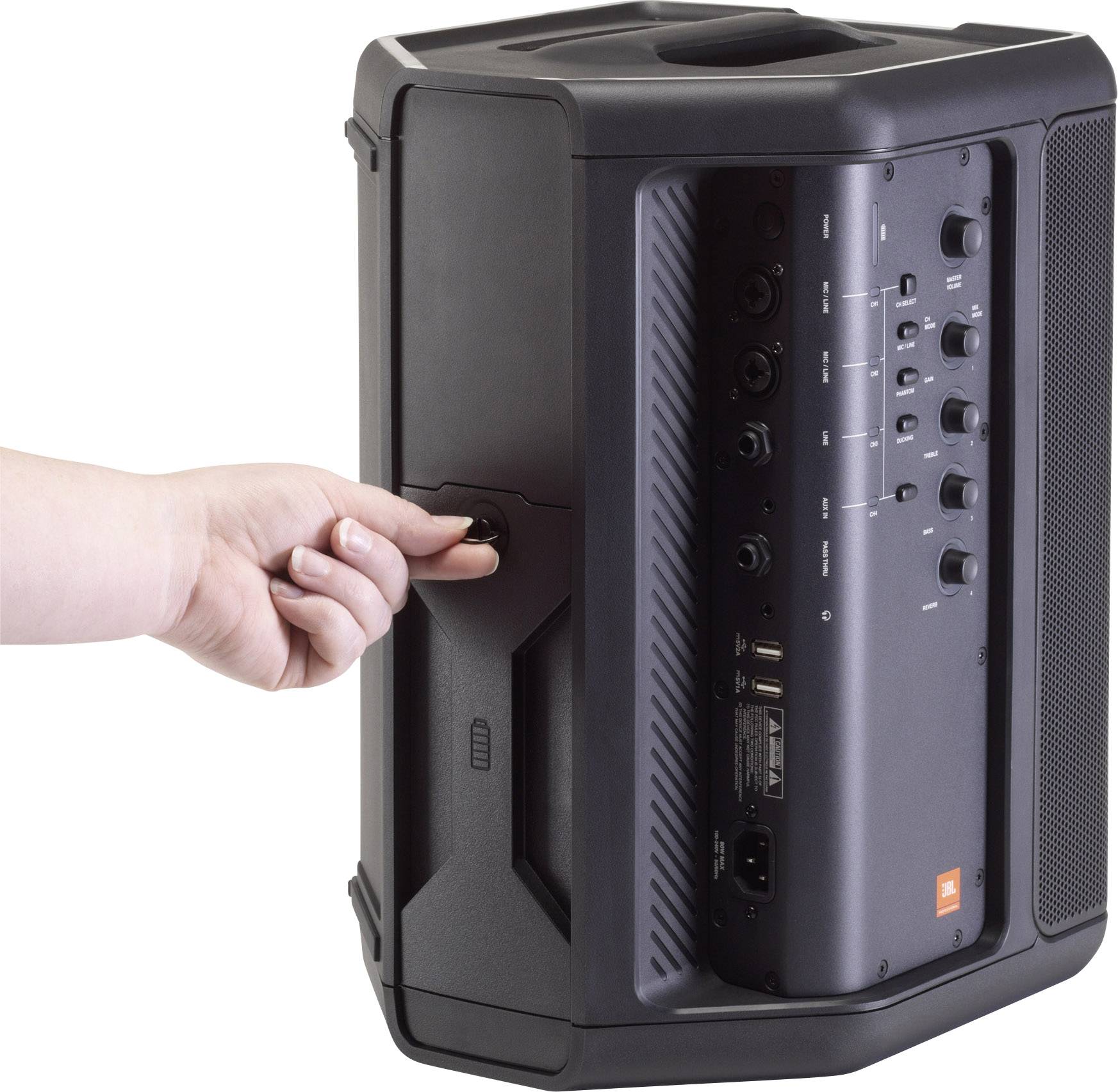 Une personne tourne le bouton de volume sur un haut-parleur portable doté de plusieurs connexions et commandes sur le côté.