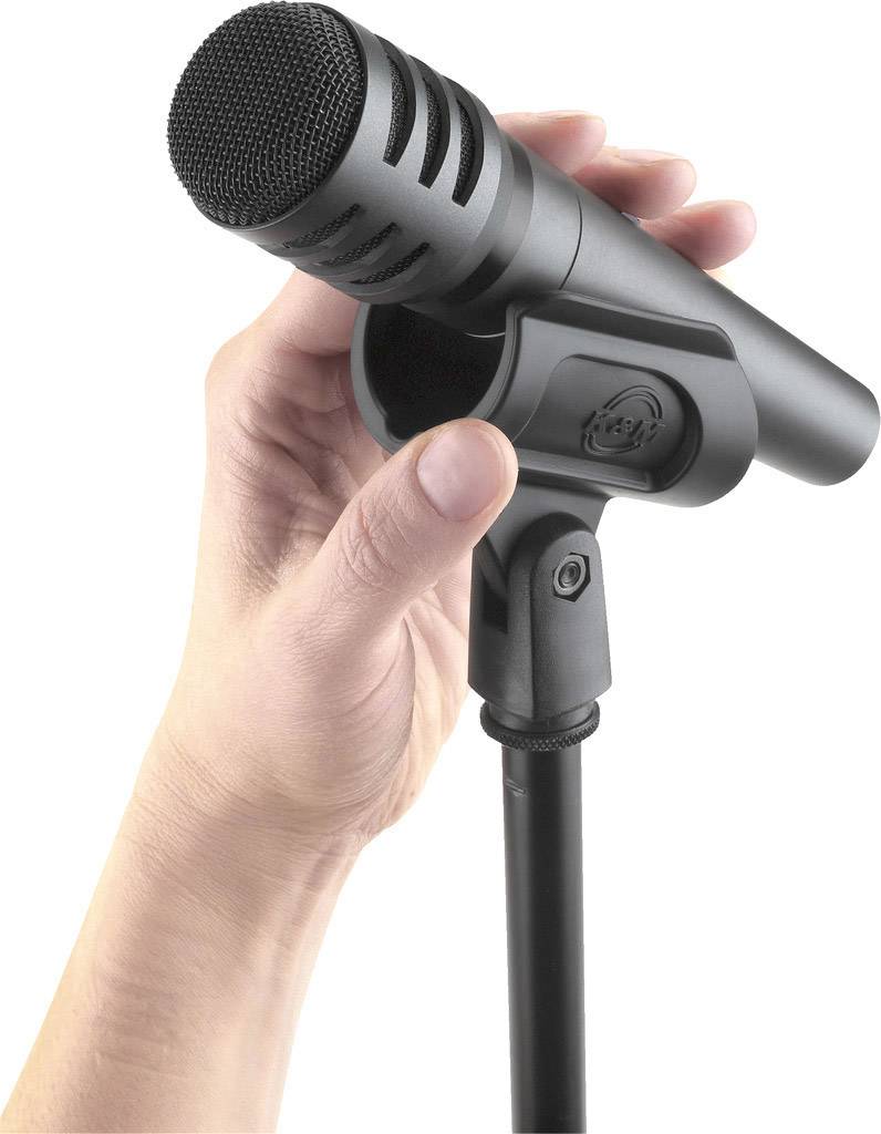 Microphone tenu dans une main, prêt à parler ou à chanter. Design professionnel noir. Focus sur la tête du microphone.