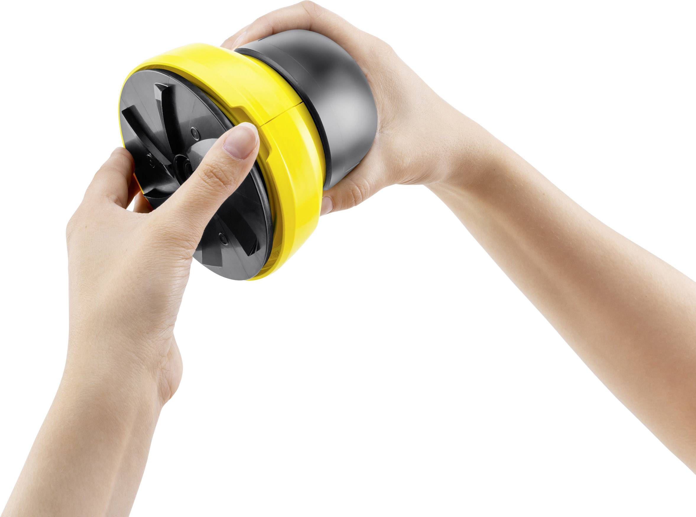 Une personne tient un coupe-légumes manuel spiralé rond avec des parties jaunes et noires, prêt à couper des légumes.