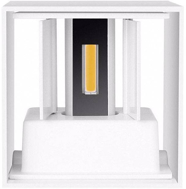 Un objet lumineux de forme cubique au design moderne, avec un élément central orange vif, entouré de parois blanches.