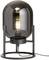 Une lampe de table moderne avec un cadre en métal noir et une ampoule recouverte de verre qui émet une lumière chaleureuse.