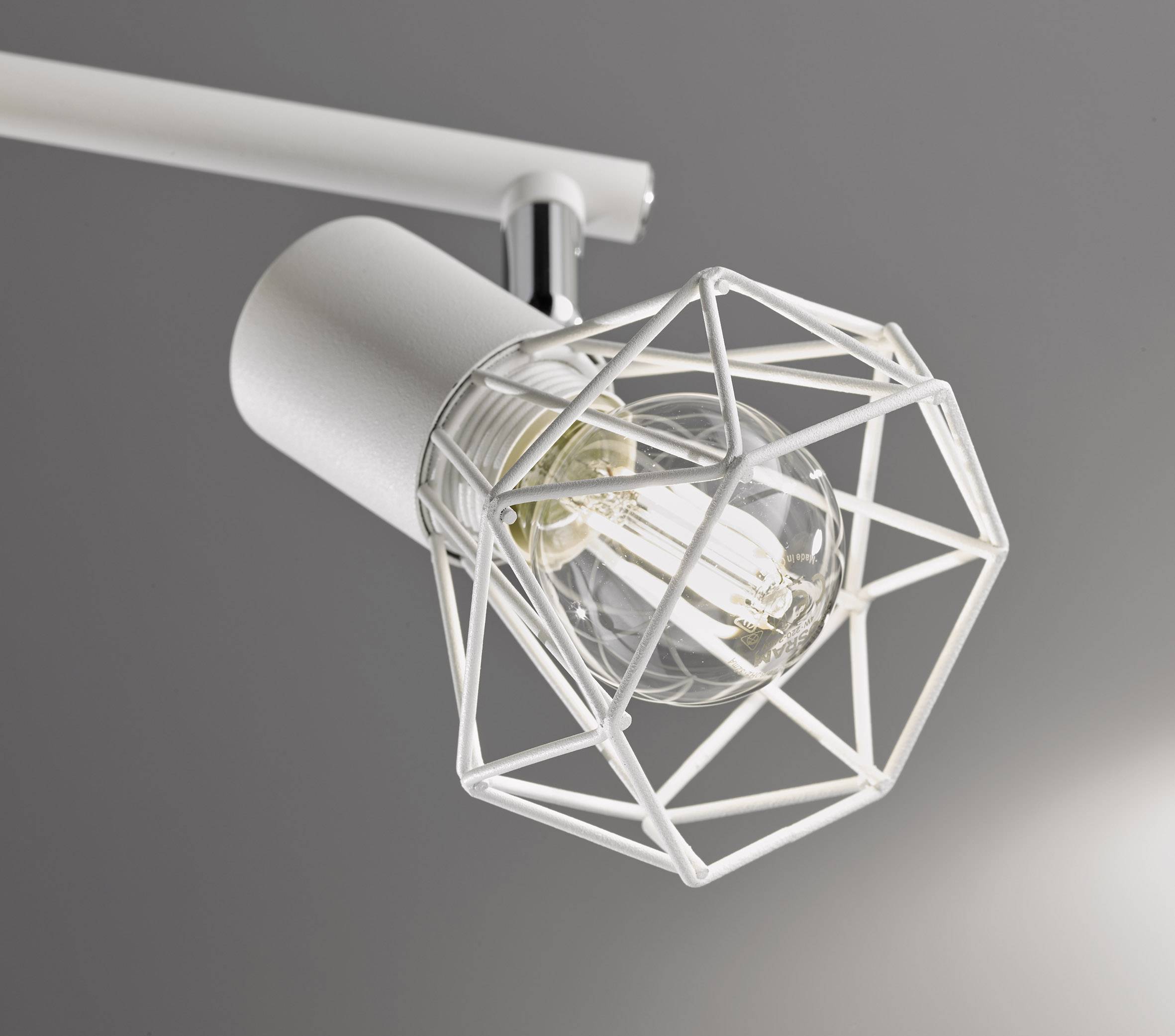 Une lampe de plafond moderne avec un cadre métallique géométrique entourant une ampoule, sur un fond gris.