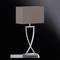 Une lampe de table moderne avec un abat-jour rectangulaire brun et un socle incurvé argenté sur un fond noir.
