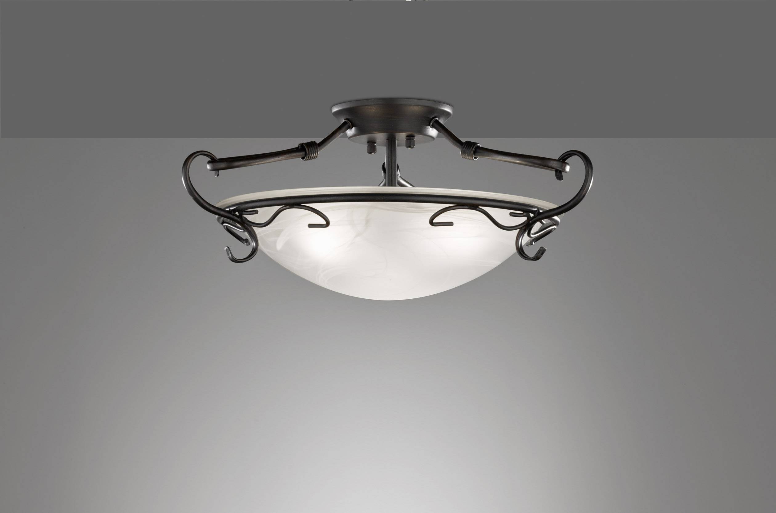 Plafonnier à décorations métalliques et abat-jour rond en verre de lait blanc, monté au plafond.