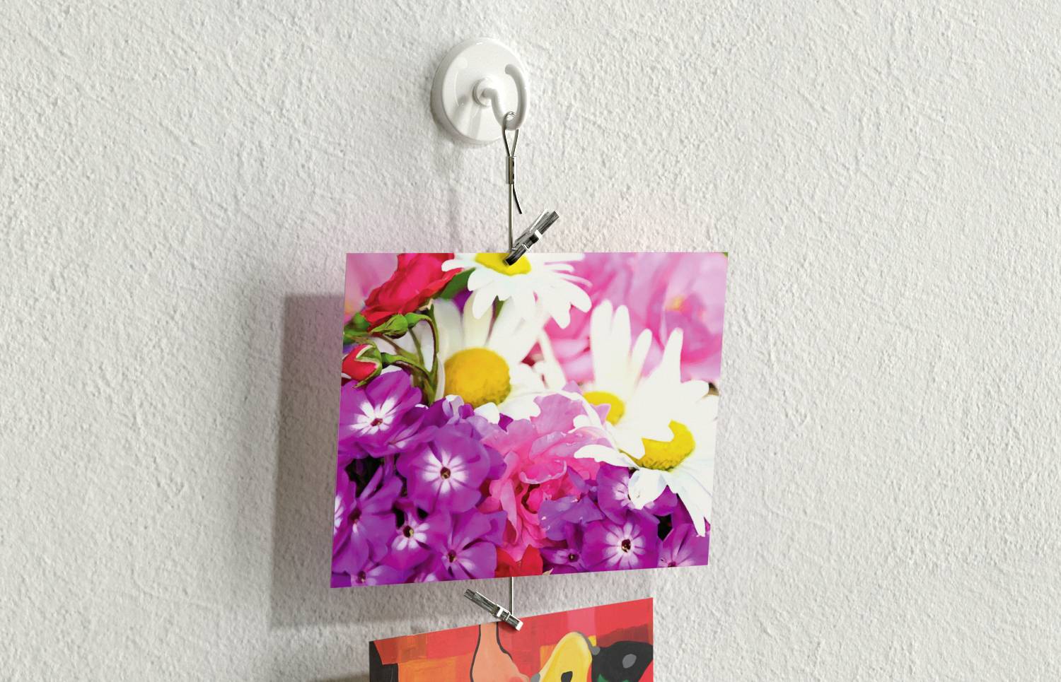 Une photo de fleurs colorées, comprenant des marguerites blanches et des fleurs violettes, est accrochée à un support mural blanc.