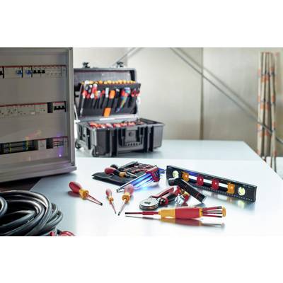 Ensemble d'outils comprenant des tournevis et des pinces sur une table, à côté d'une boîte à outils ouverte et d'un coffret électrique.
