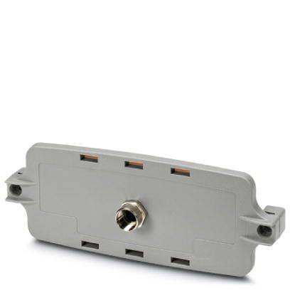 Un appareil gris rectangulaire avec une fixation métallique au centre, probablement un connecteur ou un capteur.