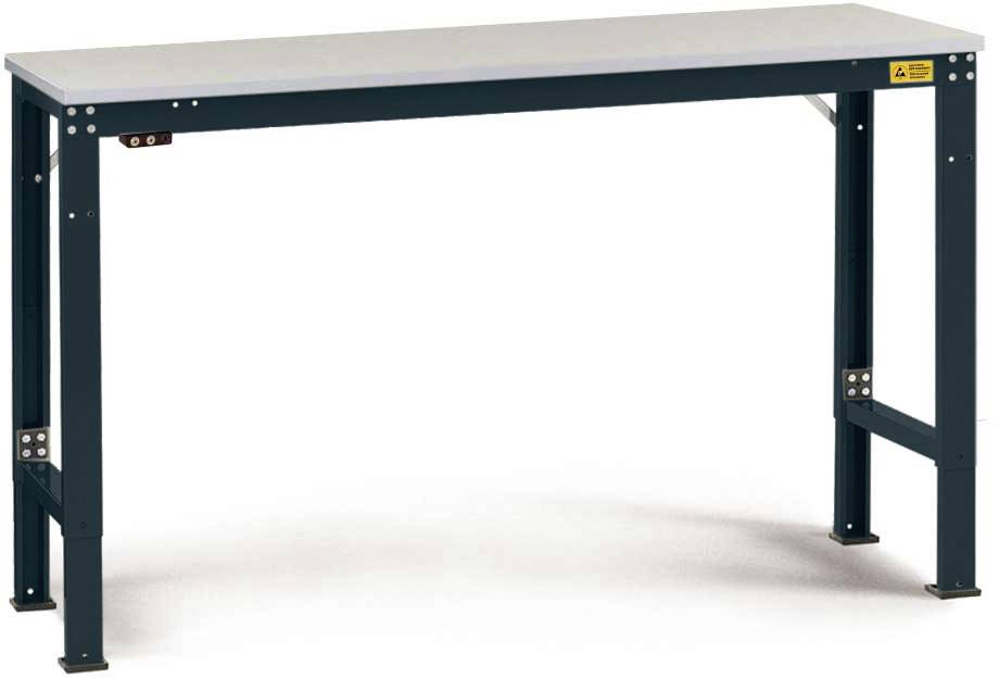 Table en métal avec un plateau rectangulaire gris. Quatre pieds solides de couleur sombre avec des vis apparentes. Adaptée pour les ateliers.