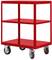 Chariot métallique rouge, robuste, avec trois étagères et quatre grandes roues pivotantes, adapté au transport d'objets lourds.