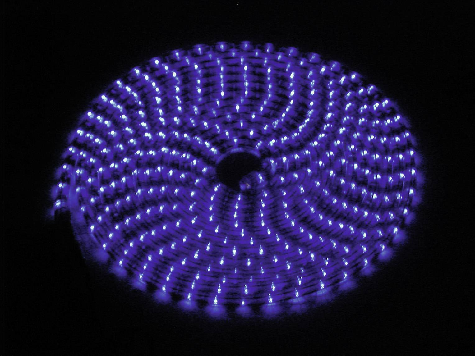 Lampe éolienne lumineuse en bleu foncé, présentant une disposition spiralée de petites lumières sur un fond noir.