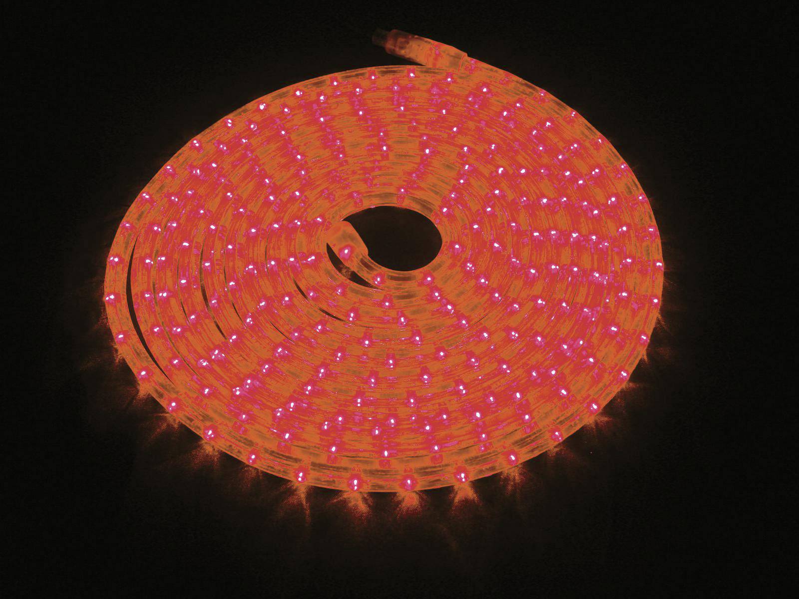 Une bande lumineuse LED rouge vif, enroulée sur un fond noir, produit une lumière brillante et uniforme.