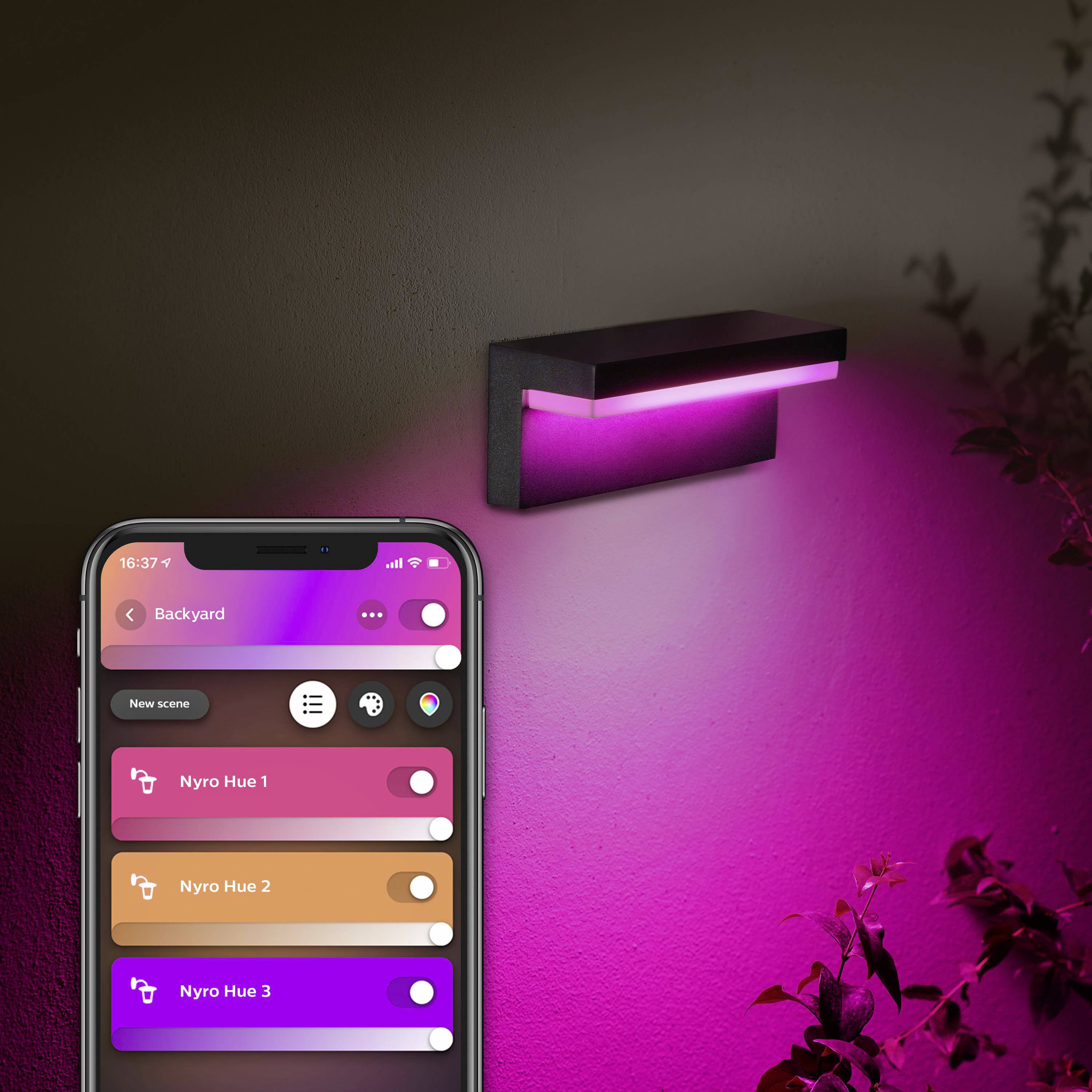Un smartphone affiche une application permettant de contrôler des lumières colorées dans le jardin, qui brillent en rose.
