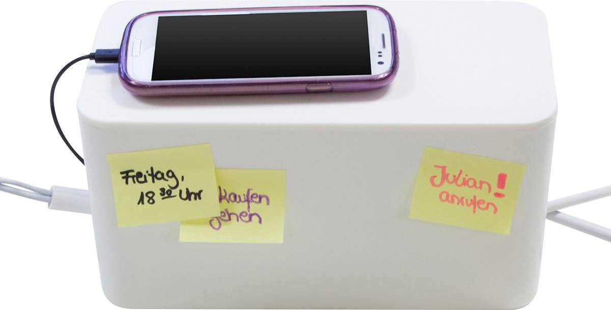 Un smartphone est posé sur une boîte blanche. Sur la boîte, trois post-it avec des notes : 'Vendredi, 18h00' et 'Appeler Julian !'.
