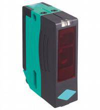 Capteur optoélectronique dans un boîtier vert de forme rectangulaire. Composant principal d'un système de sécurité.