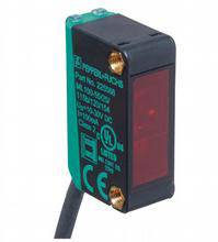 Capteur électronique avec boîtier noir et façade rouge. Câble de connexion visible. Adapté pour la détection d'objets.