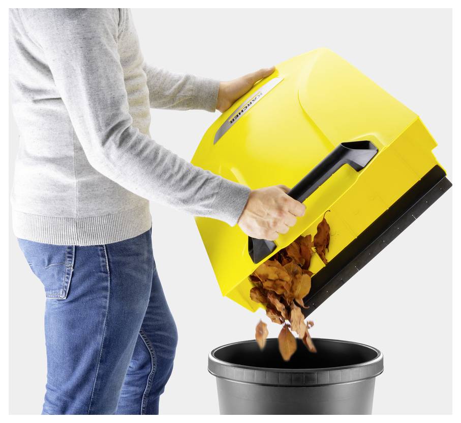 Une personne vide un bac d'aspirateur jaune rempli de débris dans une poubelle noire, démontrant une élimination facile.