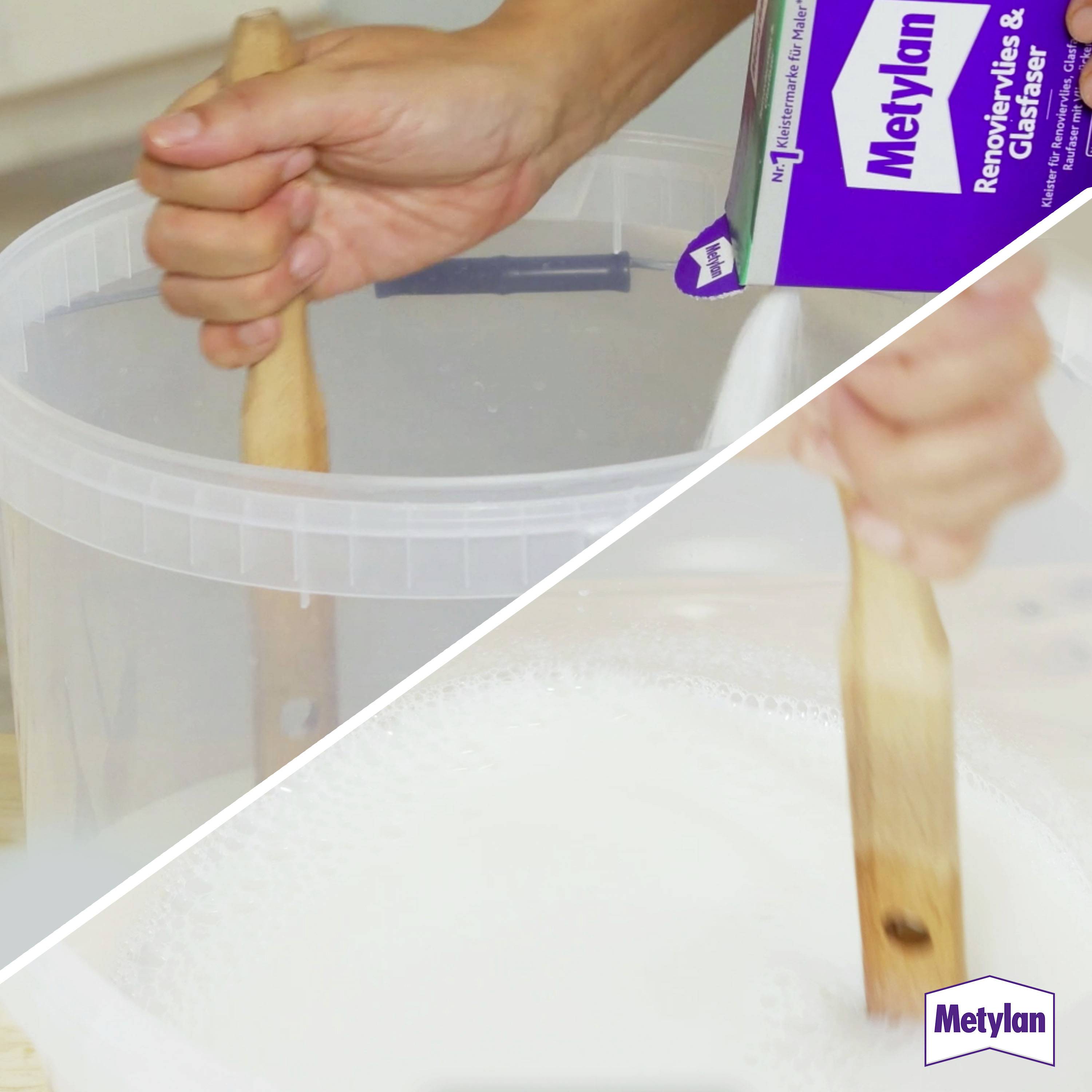 Une personne remue un mélange blanc dans un grand récipient en plastique à l'aide d'un bâton en bois. Une boîte de colle à papier peint Metylan est visible.