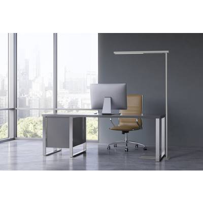 Un bureau moderne avec une grande fenêtre, un bureau, un écran d'ordinateur et une chaise de bureau marron. Skyline en arrière-plan.