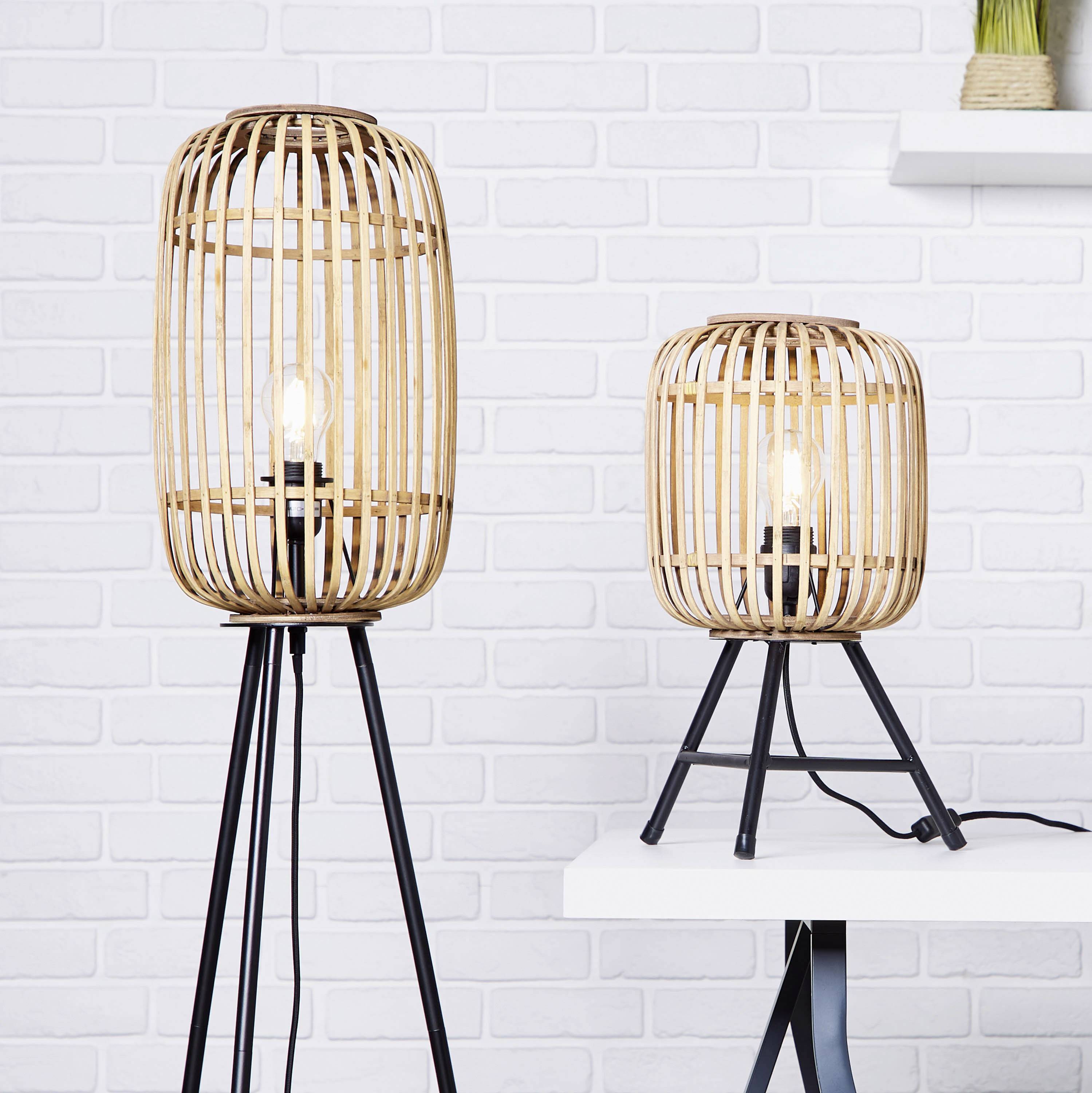 Deux lampes sur pied décoratives avec abat-jour en rotin et pied en métal devant un mur de briques blanches. Une lampe est posée sur une table.