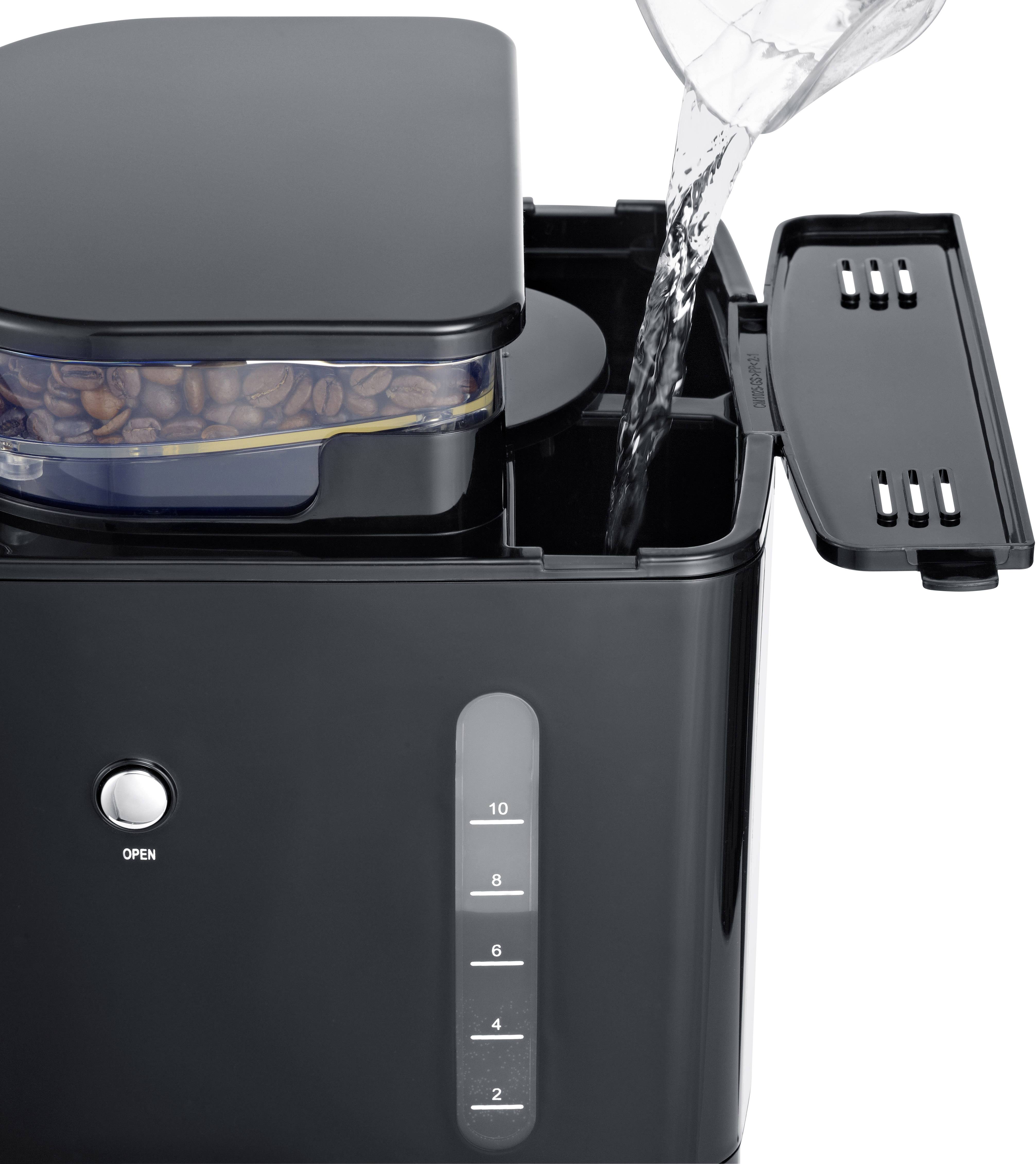Machine à café avec compartiment à grains, l'eau est versée à côté.