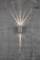 Lampe murale grise projetant une lumière chaude vers le haut et vers le bas sur un mur de béton rugueux et gris.