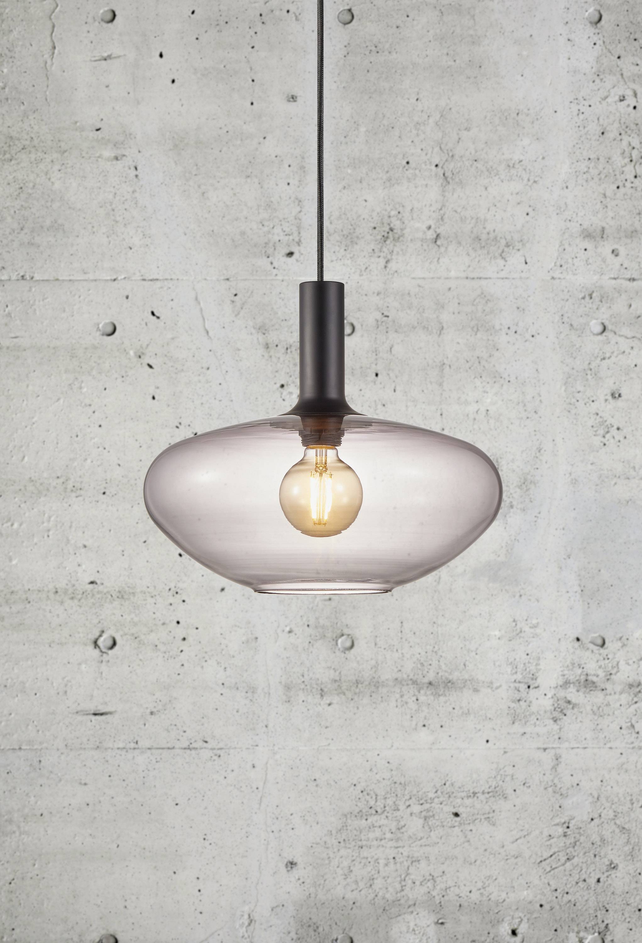 Lampe suspendue moderne avec verre transparent et ampoule apparente, suspendue devant un mur en béton gris.
