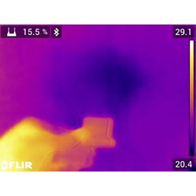 L'image thermique montre une main tenant un appareil photo. La température est échelonnée de 20,4 à 29,1 degrés Celsius. Le coin supérieur gauche affiche l'indicateur de batterie.