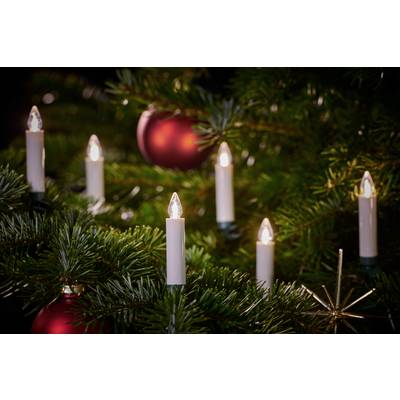 Un sapin de Noël joliment décoré avec des boules rouges et des bougies blanches scintillantes.