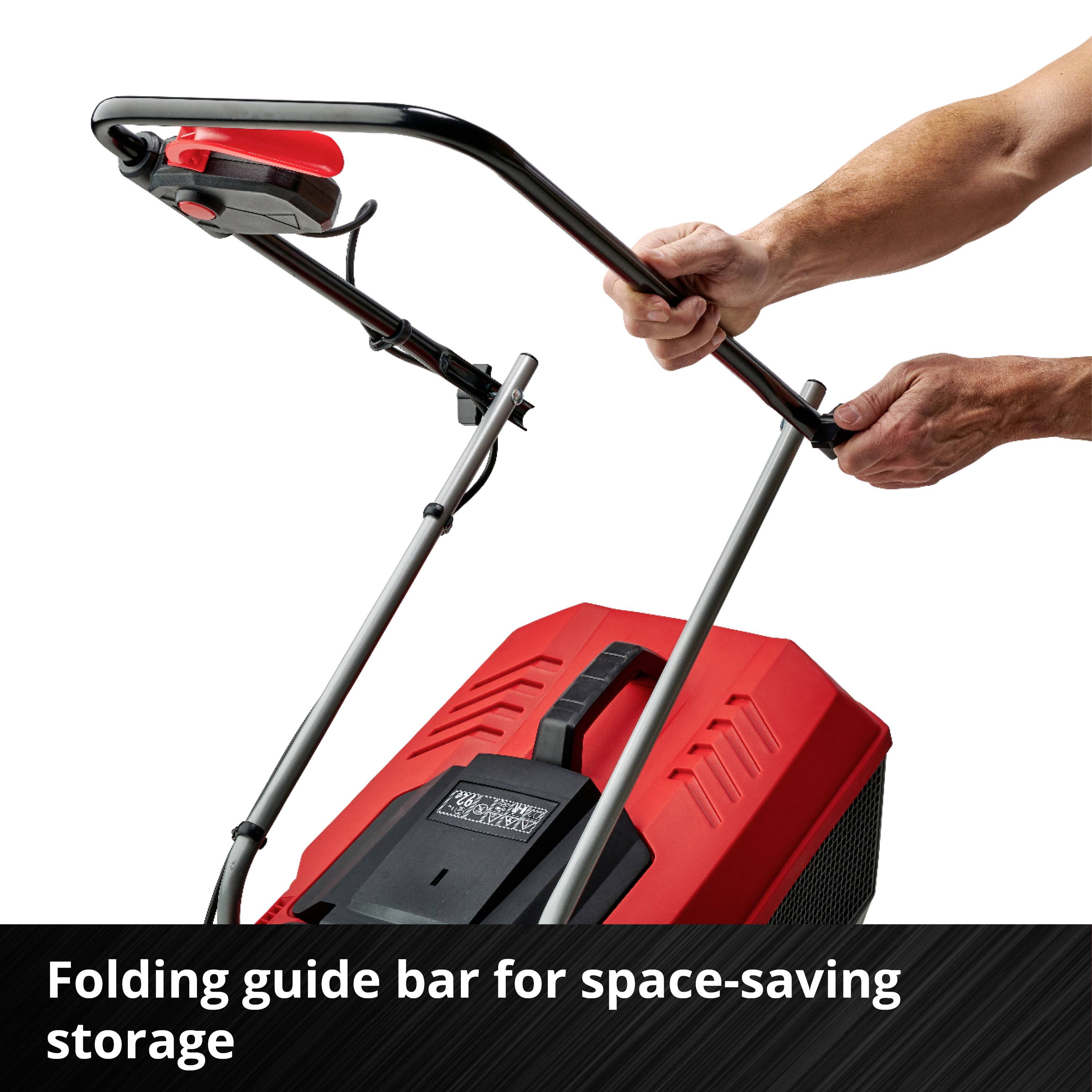 Main masculine pliant la poignée de guidage d'une tondeuse à gazon.