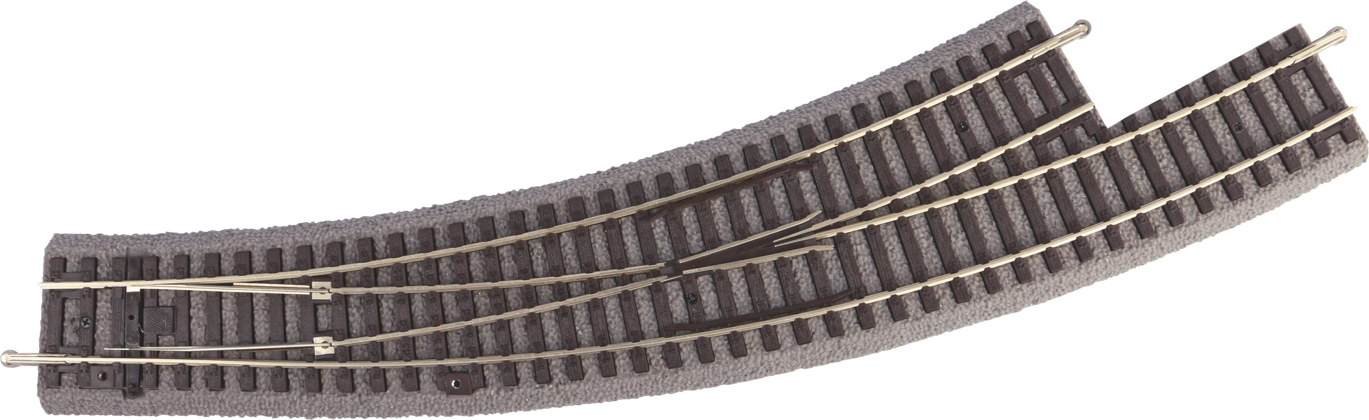 Un rail de train miniature avec deux aiguillages montre une bifurcation en courbe. Les rails sont fixés sur du ballast gris.
