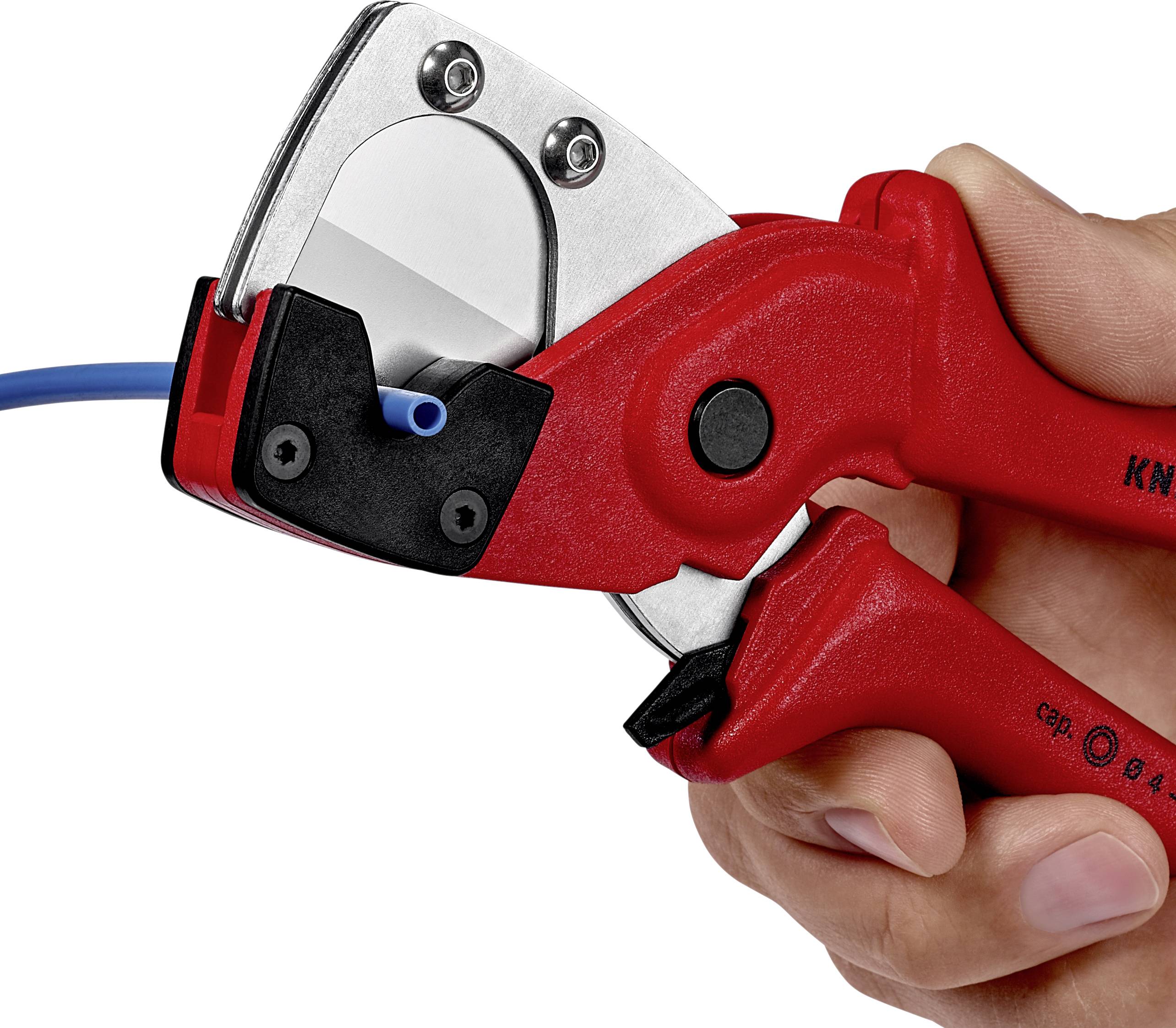 Une main tient un coupe-câble rouge qui coupe un câble bleu. La pince présente des détails métalliques et noirs.