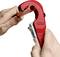 Une main utilise un coupe-tube rouge pour couper un tuyau en cuivre.